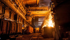 Interior of a steel mill, with open flames present as part of the production process