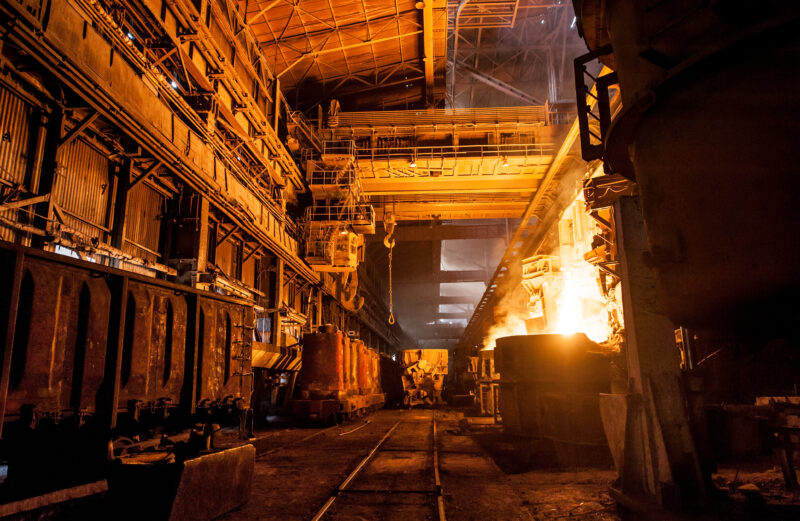 Interior of a steel mill, with open flames present as part of the production process